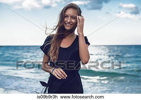 Stock Image - Portrait of happy young woman on beach, Odessa, Odessa Oblast, Ukraine. Fotosearch