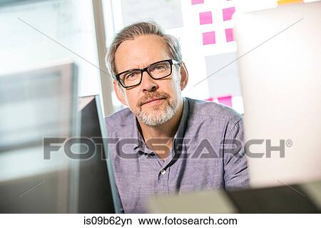 Portrait of mature male digital designer at office desk View Large Photo Image Picture - Portrait of mature male digital designer at office desk. Fotosearch