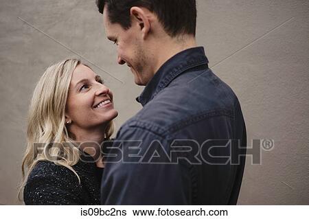 Stock Photograph - Portrait of mid adult couple, face to face, smiling. Fotosearch