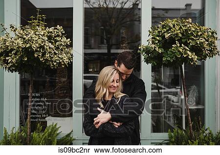 Portrait of mid adult couple in street, man hugging woman View Large Photo Image Stock Photography - Portrait of mid adult couple in street, man hugging woman. Fotosearch
