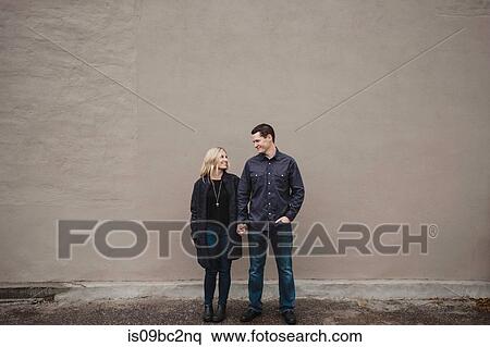 Stock Photography - Portrait of mid adult couple outdoors, holding hands, smiling. Fotosearch