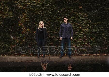Portrait of mid adult couple, standing in front of foliage View Large Photo Image Stock Photograph - Portrait of mid adult couple, standing in front of foliage. Fotosearch