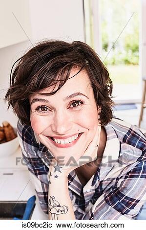 Stock Image - Portrait of mid adult woman, smiling. Fotosearch