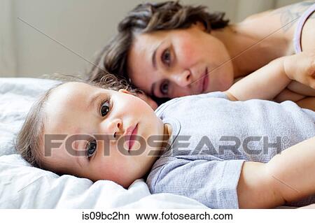 Portrait of mother and baby daughter, relaxing on bed View Large Photo Image Picture - Portrait of mother and baby daughter, relaxing on bed. Fotosearch