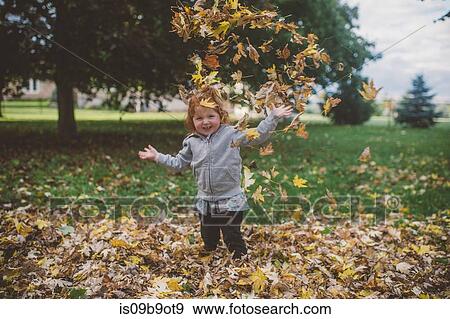 Portrait of red haired female toddler in park throwing autumn leaves View Large Photo Image Stock Photo - Portrait of red haired female toddler in park throwing autumn leaves. Fotosearch