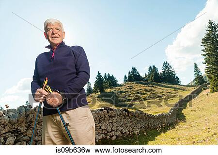 Portrait of senior man in rural setting, holding walking poles, Geneva, Switzerland, Europe View Large Photo Image Stock Photo - Portrait of senior man in rural setting, holding walking poles, Geneva, Switzerland, Europe. Fotosearch