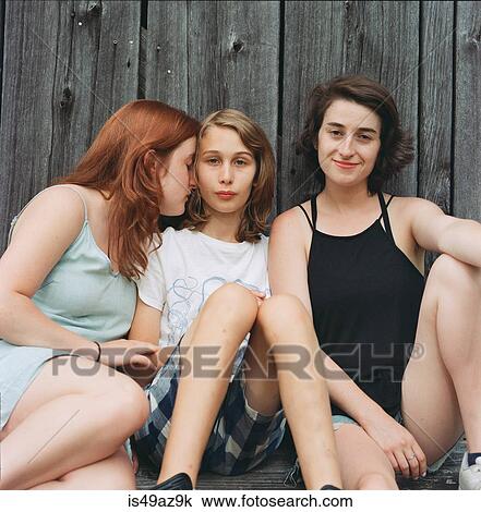Portrait of teenage boy sitting with two young women, outdoors View Large Photo Image Stock Image - Portrait of teenage boy sitting with two young women, outdoors. Fotosearch