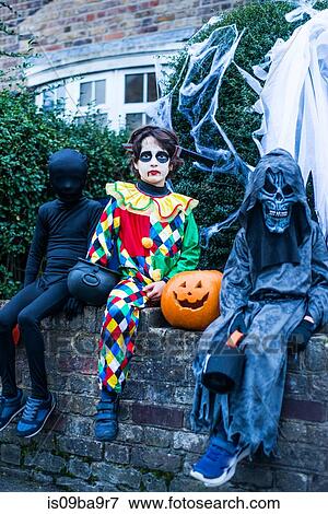 Portrait of three boys in halloween costumes, sitting on wall View Large Photo Image Stock Photo - Portrait of three boys in halloween costumes, sitting on wall. Fotosearch