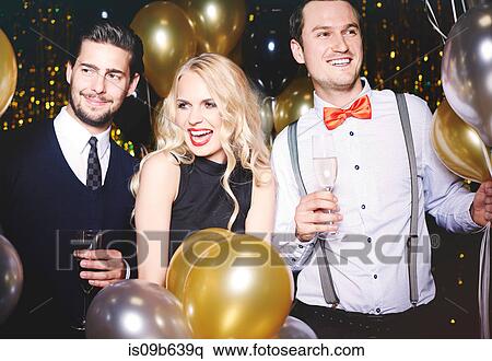 Portrait of three people at party, surrounded by balloons, holding champagne glasses View Large Photo Image Stock Photography - Portrait of three people at party, surrounded by balloons, holding champagne glasses. Fotosearch