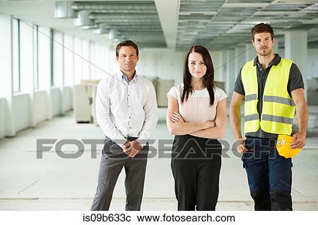 Stock Image - Portrait of three workers, standing in newly constructed office space. Fotosearch