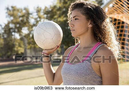 Portrait of woman holding football looking away View Large Photo Image Stock Image - Portrait of woman holding football looking away. Fotosearch