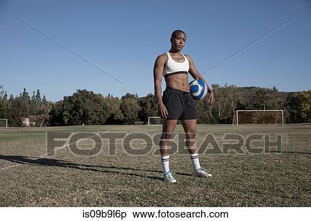 Portrait of woman holding football looking at camera View Large Photo Image Stock Photography - Portrait of woman holding football looking at camera. Fotosearch