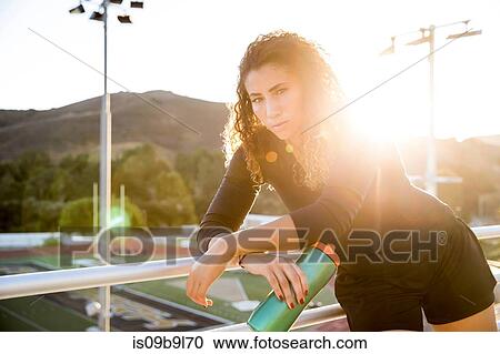 Portrait of woman holding water bottle looking at camera View Large Photo Image Stock Image - Portrait of woman holding water bottle looking at camera. Fotosearch