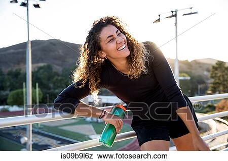Portrait of woman holding water bottle looking away smiling View Large Photo Image Stock Photo - Portrait of woman holding water bottle looking away smiling. Fotosearch
