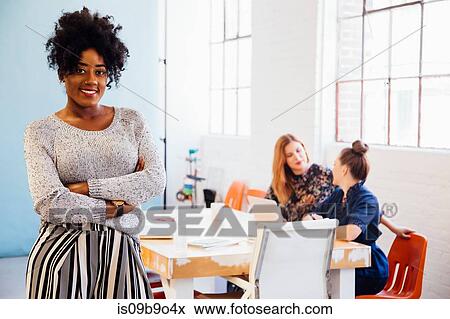 Stock Photo - Portrait of woman in office looking at camera smiling. Fotosearch