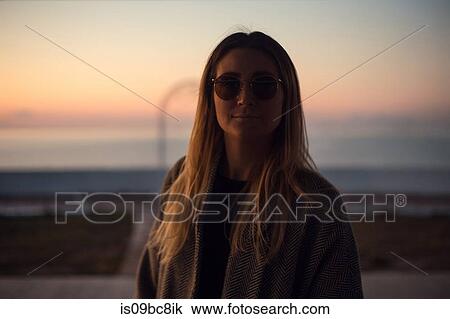 Portrait of woman in shade wearing sunglasses looking at camera smiling View Large Photo Image Stock Image - Portrait of woman in shade wearing sunglasses looking at camera smiling. Fotosearch