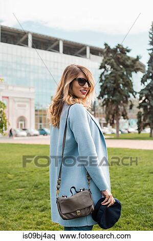 Portrait of woman looking over shoulder at camera smiling View Large Photo Image Stock Photography - Portrait of woman looking over shoulder at camera smiling. Fotosearch