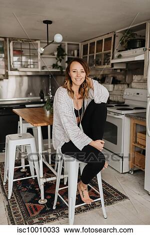 Portrait of woman on high stool in kitchen View Large Photo Image Stock Image - Portrait of woman on high stool in kitchen. Fotosearch