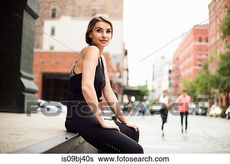 Portrait of woman sitting on wall looking at camera, New York, USA View Large Photo Image Stock Photograph - Portrait of woman sitting on wall looking at camera, New York, USA. Fotosearch