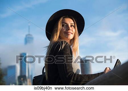 Portrait of woman wearing hat looking away smiling, New York, USA View Large Photo Image Picture - Portrait of woman wearing hat looking away smiling, New York, USA. Fotosearch