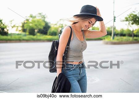 Portrait of woman wearing hat looking down smiling, New York, USA View Large Photo Image Picture - Portrait of woman wearing hat looking down smiling, New York, USA. Fotosearch