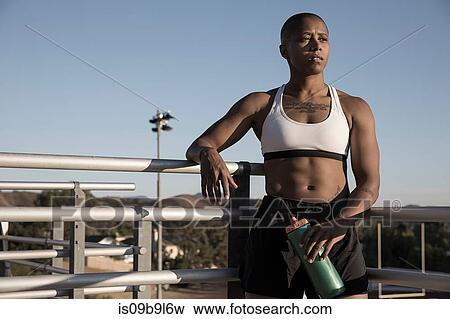 Stock Photo - Portrait of woman wearing sports clothing holding water bottle. Fotosearch