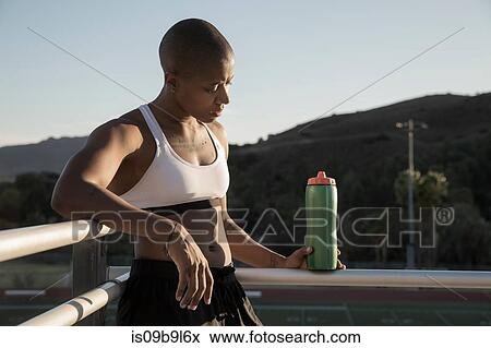 Portrait of woman wearing sports clothing holding water bottle View Large Photo Image Stock Photo - Portrait of woman wearing sports clothing holding water bottle. Fotosearch