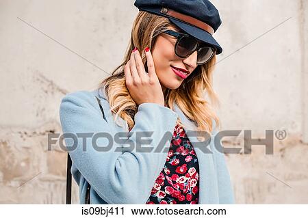 Portrait of woman wearing sunglasses and baker boy cap looking away View Large Photo Image Stock Image - Portrait of woman wearing sunglasses and baker boy cap looking away. Fotosearch
