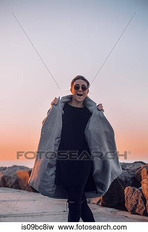 Stock Photo - Portrait of woman wearing sunglasses and winter coat posing for camera, Odessa, Odeska Oblast, Ukraine, Eastern Europe. Fotosearch
