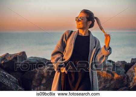 Portrait of woman wearing sunglasses and winter coat looking away smiling, Odessa, Odeska Oblast, Ukraine, Eastern Europe View Large Photo Image Stock Photo - Portrait of woman wearing sunglasses and winter coat looking away smiling, Odessa, Odeska Oblast, Ukraine, Eastern Europe. Fotosearch