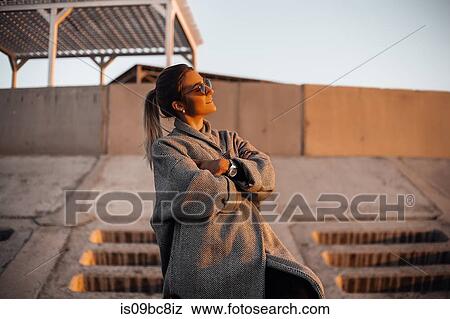 Portrait of woman wearing sunglasses and winter coat, arms folded, looking away smiling, Odessa, Odeska Oblast, Ukraine, Eastern Europe View Large Photo Image Stock Photo - Portrait of woman wearing sunglasses and winter coat, arms folded, looking away smiling, Odessa, Odeska Oblast, Ukraine, Eastern Europe. Fotosearch