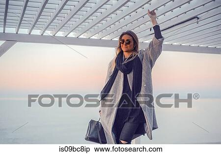 Stock Photography - Portrait of woman wearing winter coat and sunglasses looking away, Odessa, Odeska Oblast, Ukraine. Fotosearch