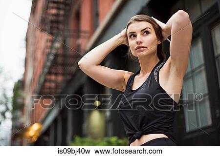 Portrait of woman with hands behind head looking away, New York, USA View Large Photo Image Stock Photo - Portrait of woman with hands behind head looking away, New York, USA. Fotosearch
