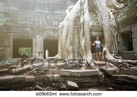 Portrait of young female tourist by tree roots at Ta Prohm temple, Angkor, Siem Reap, Cambodia View Large Photo Image Stock Photograph - Portrait of young female tourist by tree roots at Ta Prohm temple, Angkor, Siem Reap, Cambodia. Fotosearch