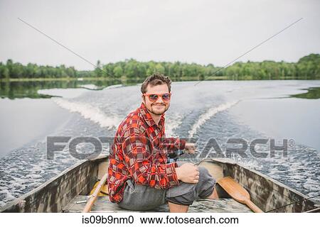 Portrait of young man in boat on lake View Large Photo Image Stock Image - Portrait of young man in boat on lake. Fotosearch