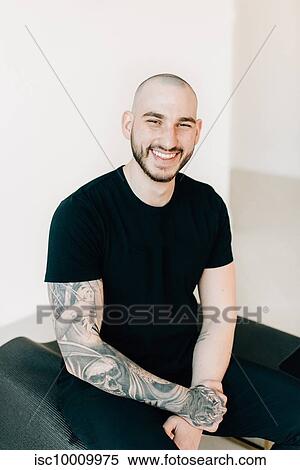Portrait of young man with tattoo in studio View Large Photo Image Stock Photography - Portrait of young man with tattoo in studio. Fotosearch