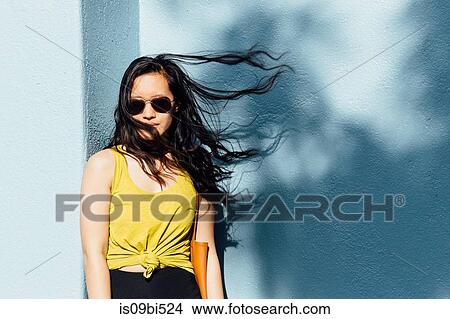Portrait of young woman outdoors, hair blowing in breeze View Large Photo Image Picture - Portrait of young woman outdoors, hair blowing in breeze. Fotosearch