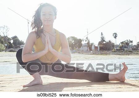 Portrait of young woman outdoors, in yoga position, Long Beach, California, USA View Large Photo Image Stock Photography - Portrait of young woman outdoors, in yoga position, Long Beach, California, USA. Fotosearch