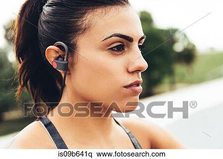 Portrait of young woman outdoors, wearing earphones close-up, South Point Park, Miami Beach, Florida, USA View Large Photo Image Stock Photography - Portrait of young woman outdoors, wearing earphones close-up, South Point Park, Miami Beach, Florida, USA. Fotosearch