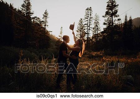 Pregnant mid adult couple holding up stetson in rural valley at sunset, Mineral King, California, USA View Large Photo Image Stock Image - Pregnant mid adult couple holding up stetson in rural valley at sunset, Mineral King, California, USA. Fotosearch