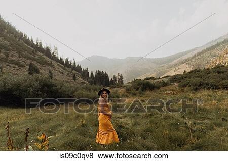Pregnant mid adult woman in orange maxi dress in rural valley, portrait, Mineral King, California, USA View Large Photo Image Stock Photo - Pregnant mid adult woman in orange maxi dress in rural valley, portrait, Mineral King, California, USA. Fotosearch