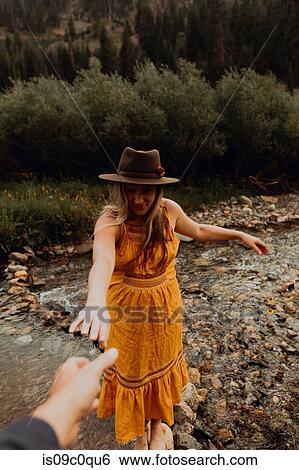 Pregnant woman in orange maxi dress reaching for hand from rural river, Mineral King, California, USA View Large Photo Image Stock Photograph - Pregnant woman in orange maxi dress reaching for hand from rural river, Mineral King, California, USA. Fotosearch
