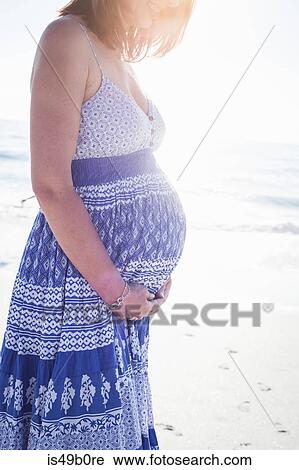 Stock Image - Pregnant woman on beach, Cape Town, South Africa. Fotosearch
