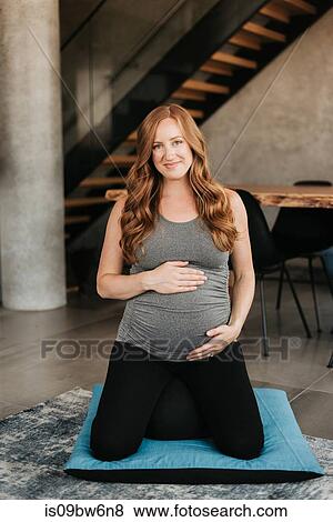 Pregnant woman on yoga mat at home View Large Photo Image Stock Photo - Pregnant woman on yoga mat at home. Fotosearch