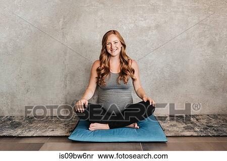 Pregnant woman on yoga mat beside concrete wall View Large Photo Image Stock Photography - Pregnant woman on yoga mat beside concrete wall. Fotosearch