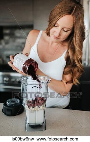 Pregnant woman preparing smoothie in kitchen View Large Photo Image Stock Photo - Pregnant woman preparing smoothie in kitchen. Fotosearch