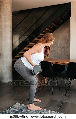 Pregnant woman using weights at home View Large Photo Image Picture - Pregnant woman using weights at home. Fotosearch