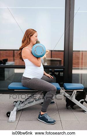 Pregnant woman using weights on balcony View Large Photo Image Stock Image - Pregnant woman using weights on balcony. Fotosearch