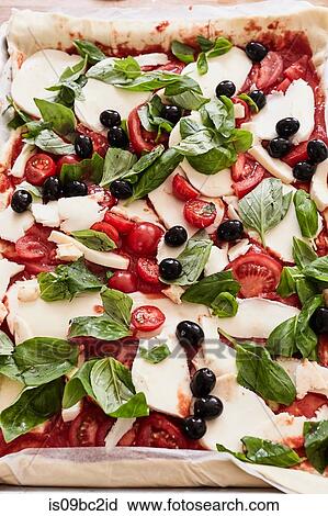 Stock Image - Prepared, uncooked pizza, close-up. Fotosearch