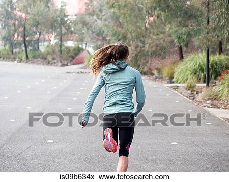 Rear view of female runner running by park View Large Photo Image Stock Photo - Rear view of female runner running by park. Fotosearch
